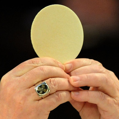 Erzbischof Reinhard Marx hält bei einem Gottesdienst in Regensburg am 28. Februar 2012 während der Wandlung die große Hostie in die Höhe. Dieses Bild ist Teil des Features 'Eucharistie'.